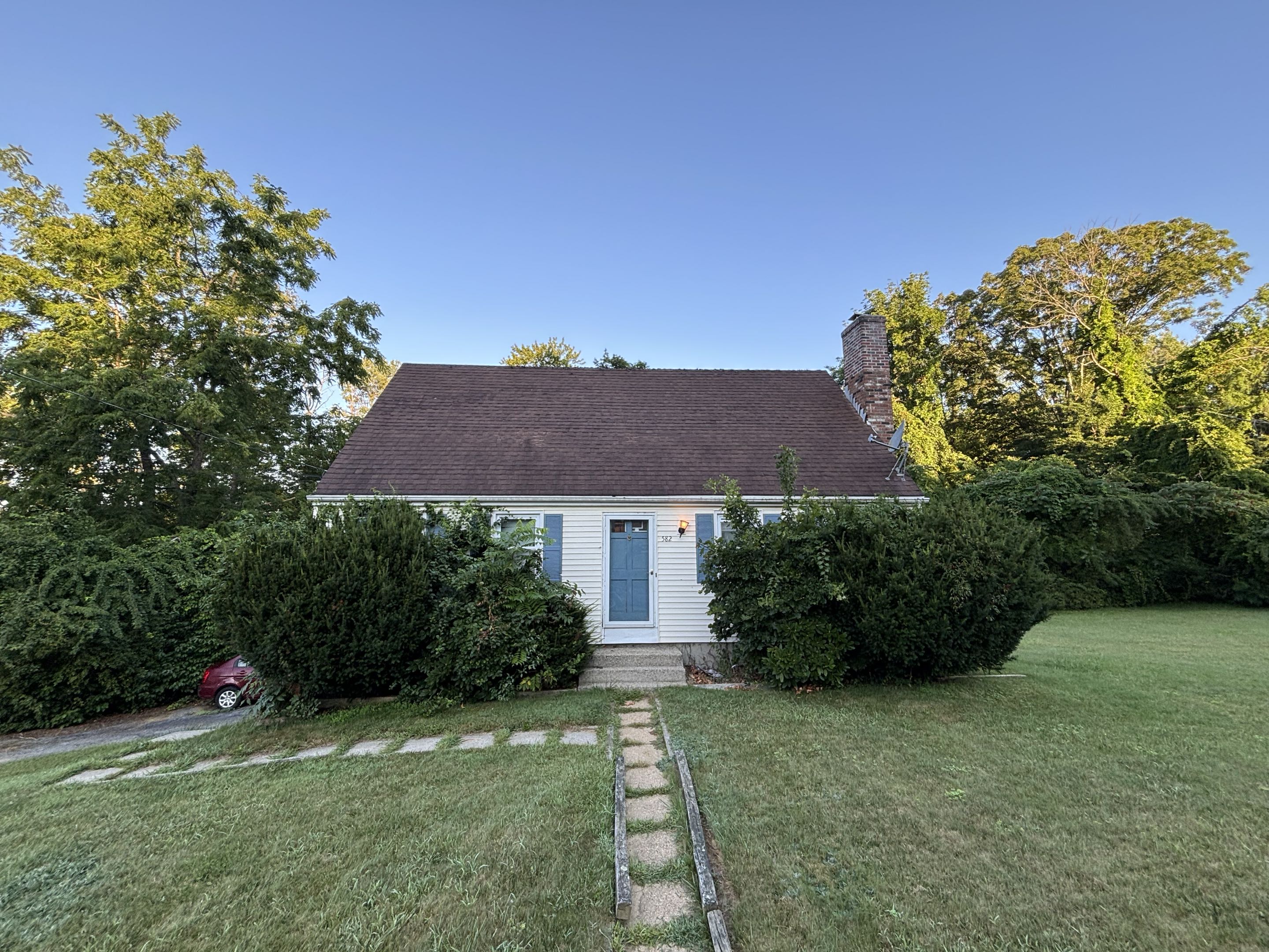 Before — overgrown shrubs covering Southbridge, MA property
